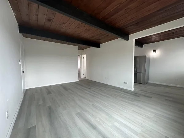 a view of empty room with wooden floor