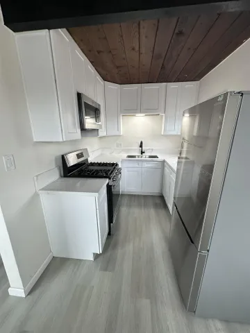 a kitchen with stainless steel appliances a refrigerator a sink a stove top oven a sink and dishwasher