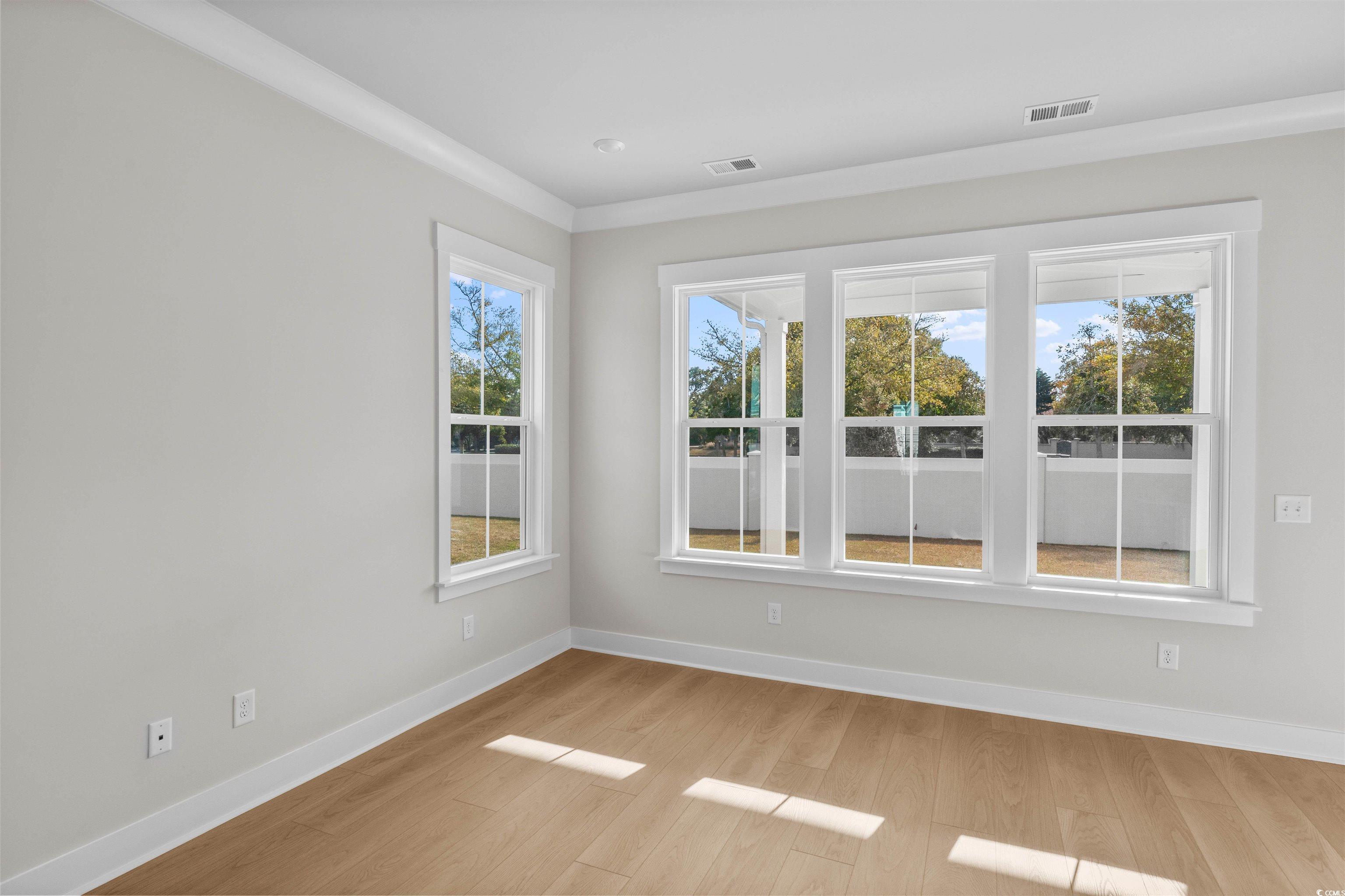 229 Atlantic Breeze Street Myrtle Beach, SC 29572 - Photo 11 of 24 Empty room with light wood-type flooring and crown molding