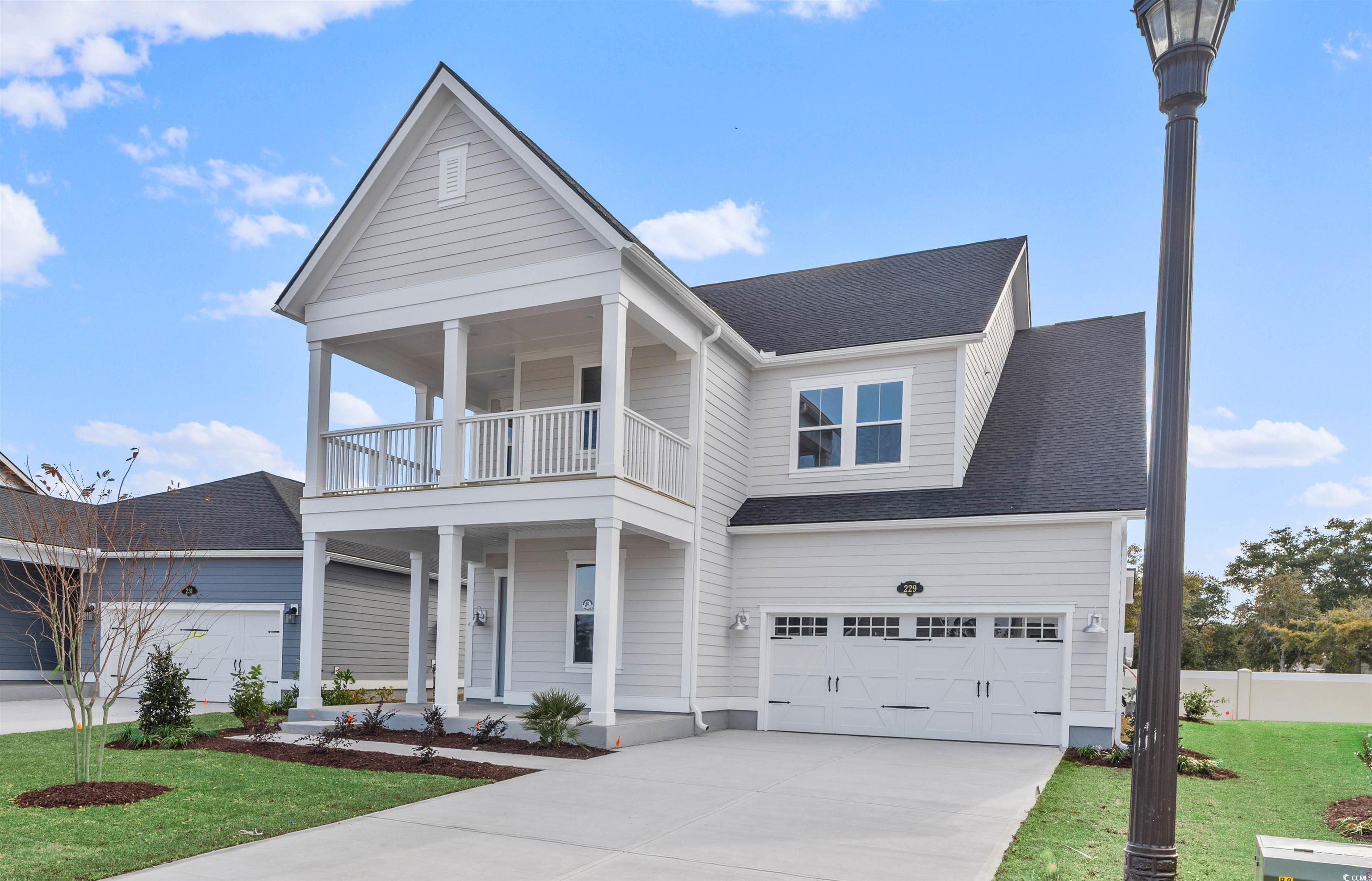 229 Atlantic Breeze Street Myrtle Beach, SC 29572 - Photo 2 of 24 View of front facade featuring covered porch, roof with shingles, concrete driveway, and a garage