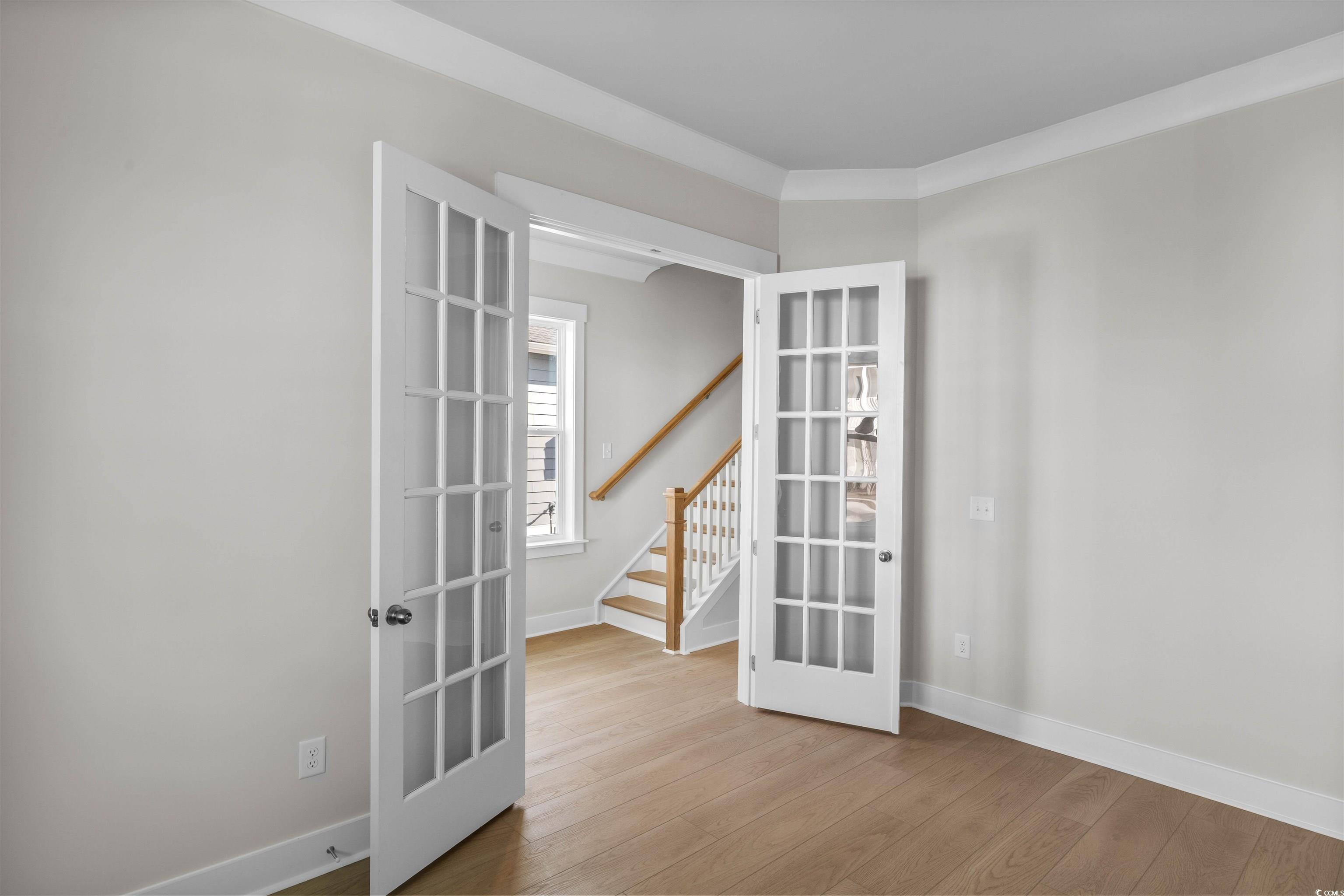 229 Atlantic Breeze Street Myrtle Beach, SC 29572 - Photo 24 of 24 Spare room with french doors, stairs, and light wood-style floors