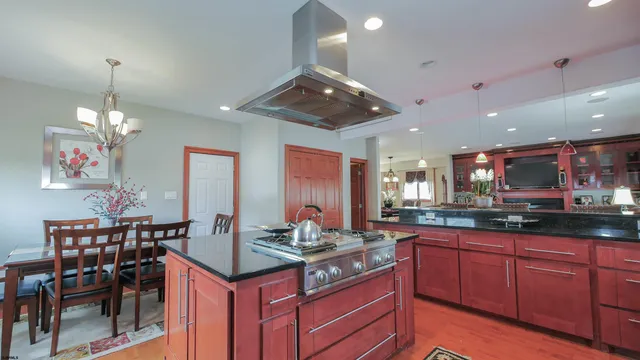 a view of a dining room with furniture a kitchen and chandelier
