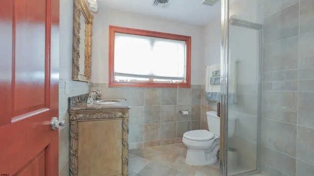 a bathroom with a granite countertop sink a toilet and shower