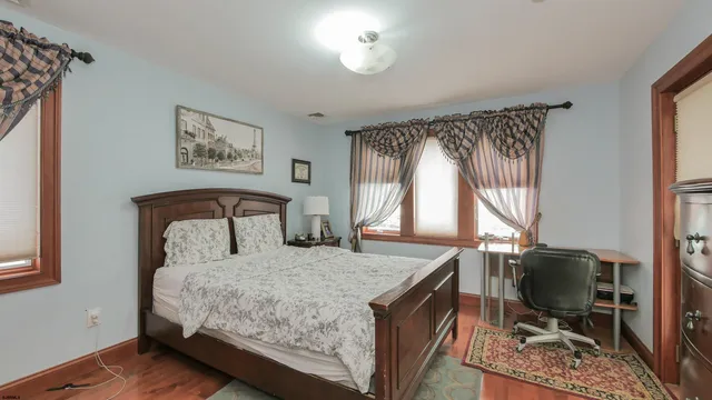 a bedroom with a bed dresser and a flat tv screen