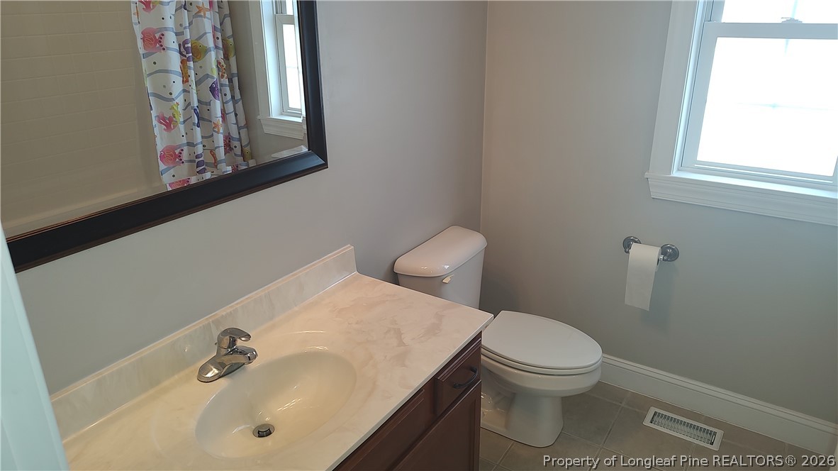 504 Brunswick Road Fayetteville, NC 28303 - Photo 26 of 50 a bathroom with a toilet a sink and mirror