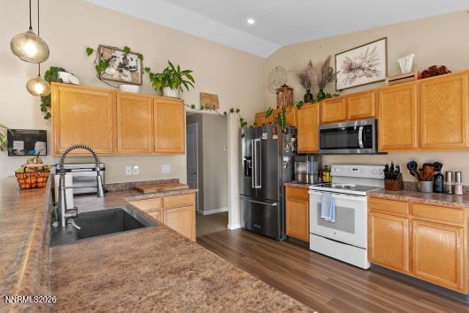 552 Spur Court Fernley, NV 89408 - Photo 20 of 46 a kitchen with stainless steel appliances granite countertop a refrigerator a stove top oven and a sink with wooden floor