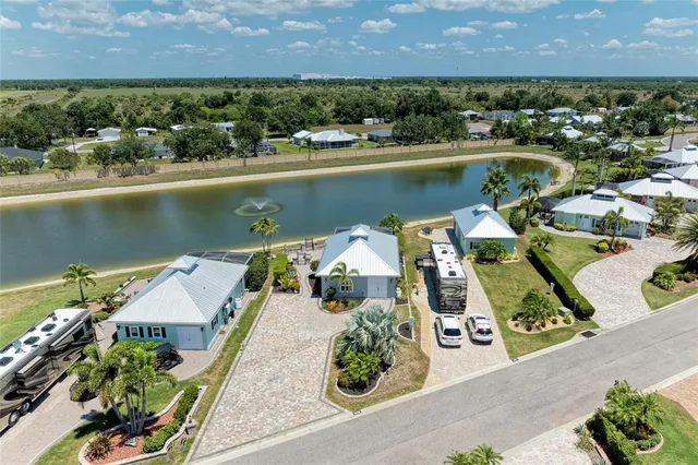 a open kitchen with stainless steel appliances granite countertop a refrigerator a stove top oven a dining table and chairs with wooden floor