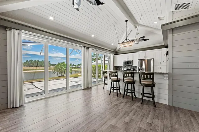 a view of a livingroom with a chandelier fan and windows