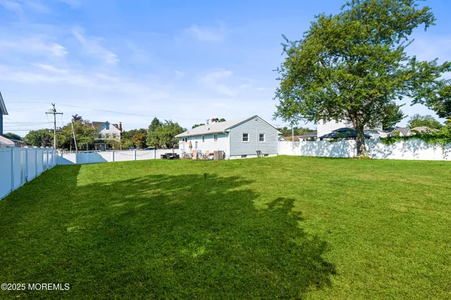 a view of a house with a big yard and large trees