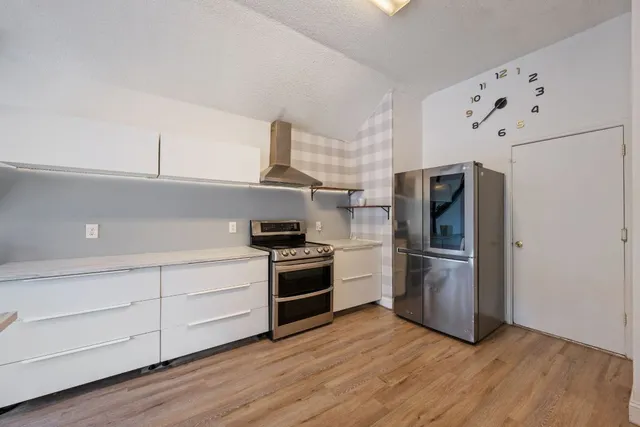 a kitchen with a refrigerator and a stove top oven