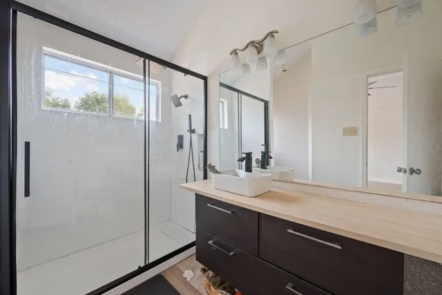 a bathroom with a sink a mirror and a shower