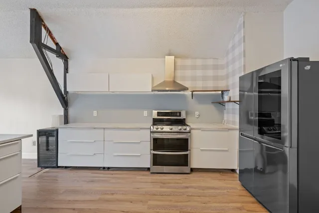 a kitchen with a refrigerator stove and white cabinets