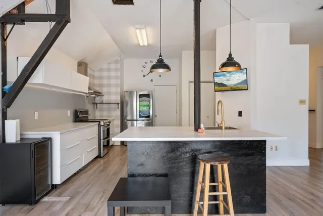 a kitchen with kitchen island stainless steel appliances a stove microwave and cabinets