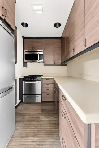 a kitchen with stainless steel appliances a stove microwave and sink