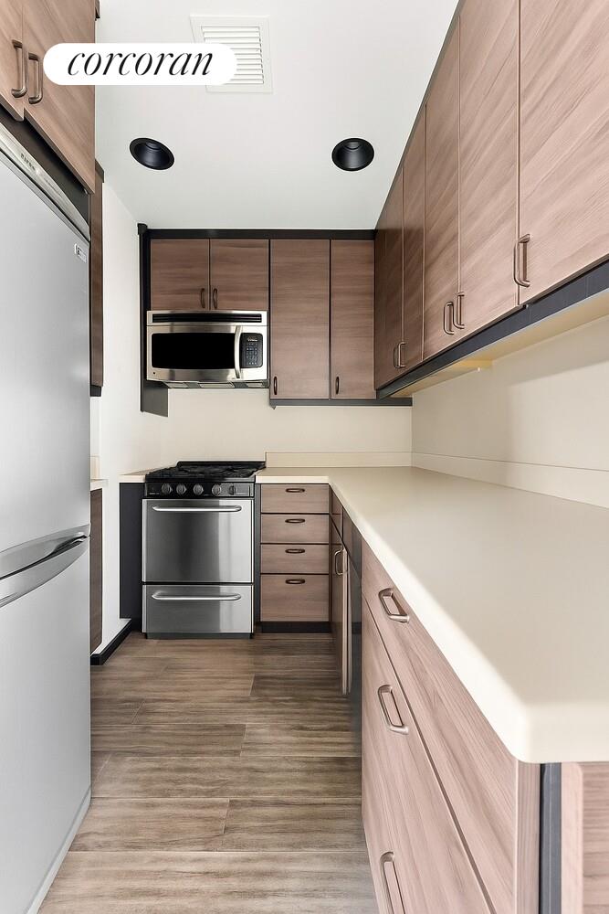 19-19 24th Avenue, Unit 102 Queens, NY 11102 - Photo 3 of 36 a kitchen with stainless steel appliances granite countertop a stove and a microwave