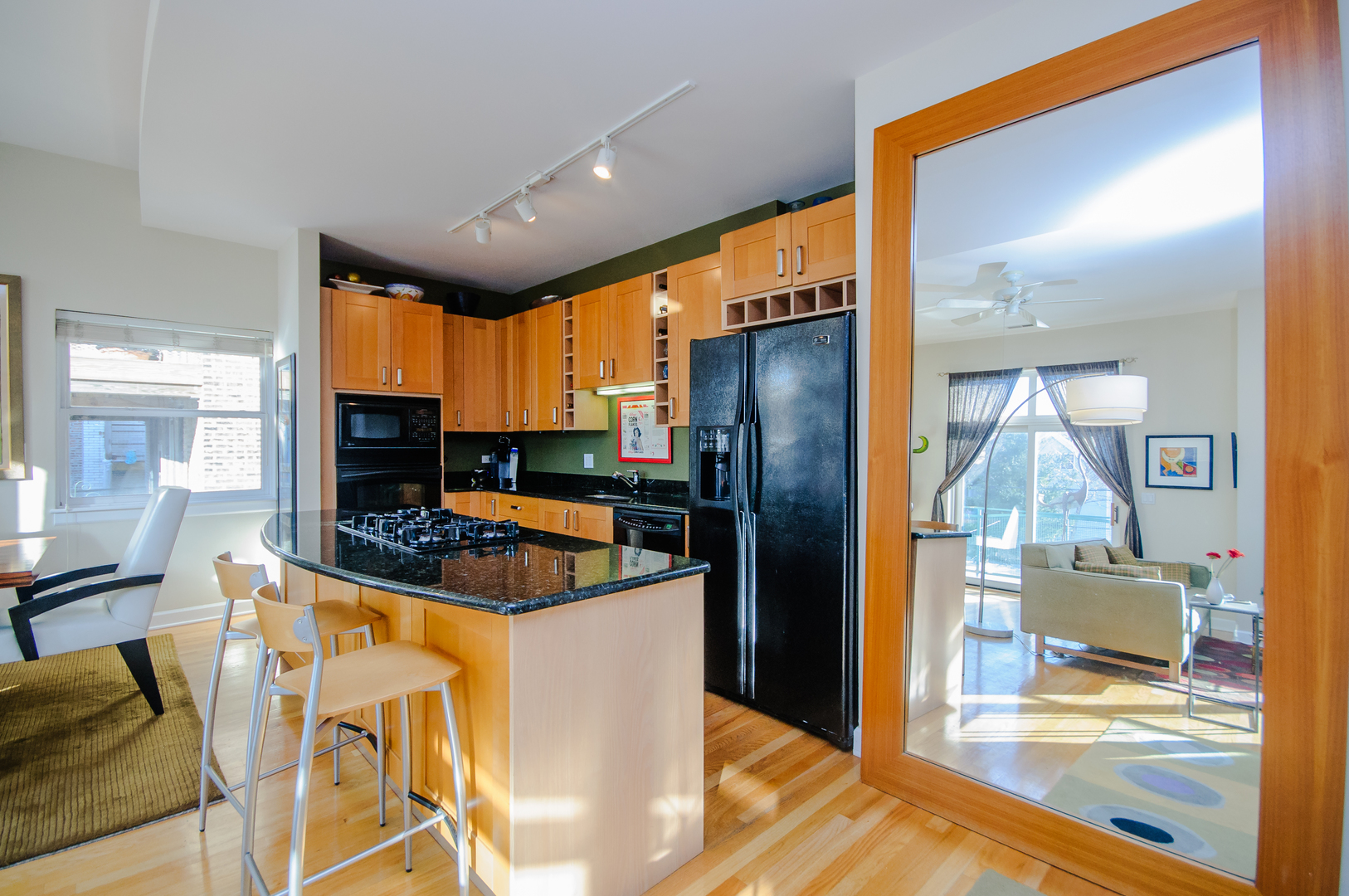 4646 North Beacon Street, Unit 203 Chicago, IL 60640 - Photo 9 of 24 a kitchen with stainless steel appliances kitchen island granite countertop a refrigerator and a stove top oven
