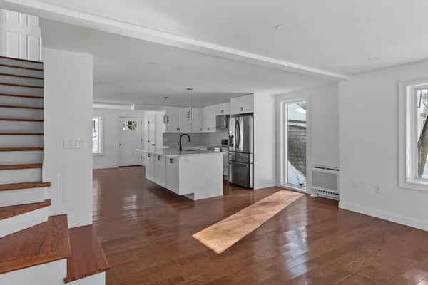 a large white kitchen with wooden floor and a kitchen