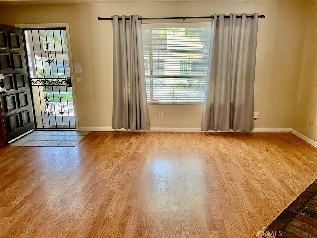 1077 South Santo Antonio Drive, Unit 15 Colton, CA 92324 - Photo 4 of 20 a view of an empty room with wooden floor and a window