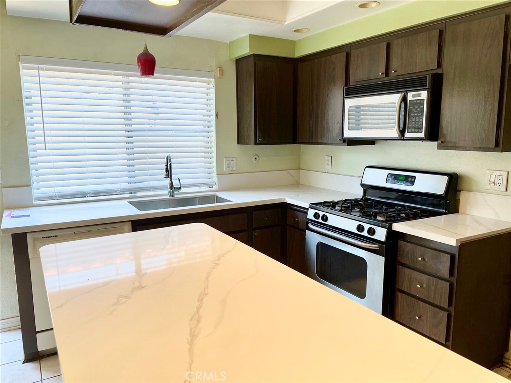 1077 South Santo Antonio Drive, Unit 15 Colton, CA 92324 - Photo 6 of 20 a kitchen that has a sink and a stove