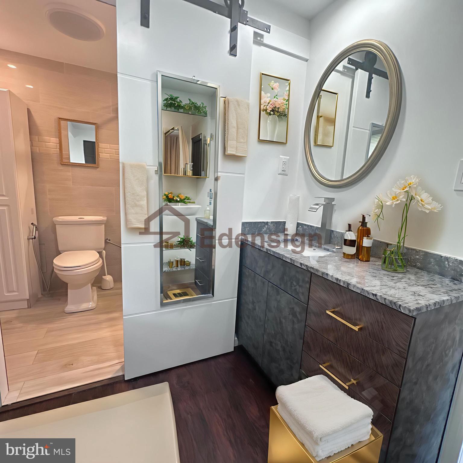 8908 Eastbourne Lane Laurel, MD 20708 - Photo 16 of 26 a bathroom with a granite countertop toilet a sink and a mirror