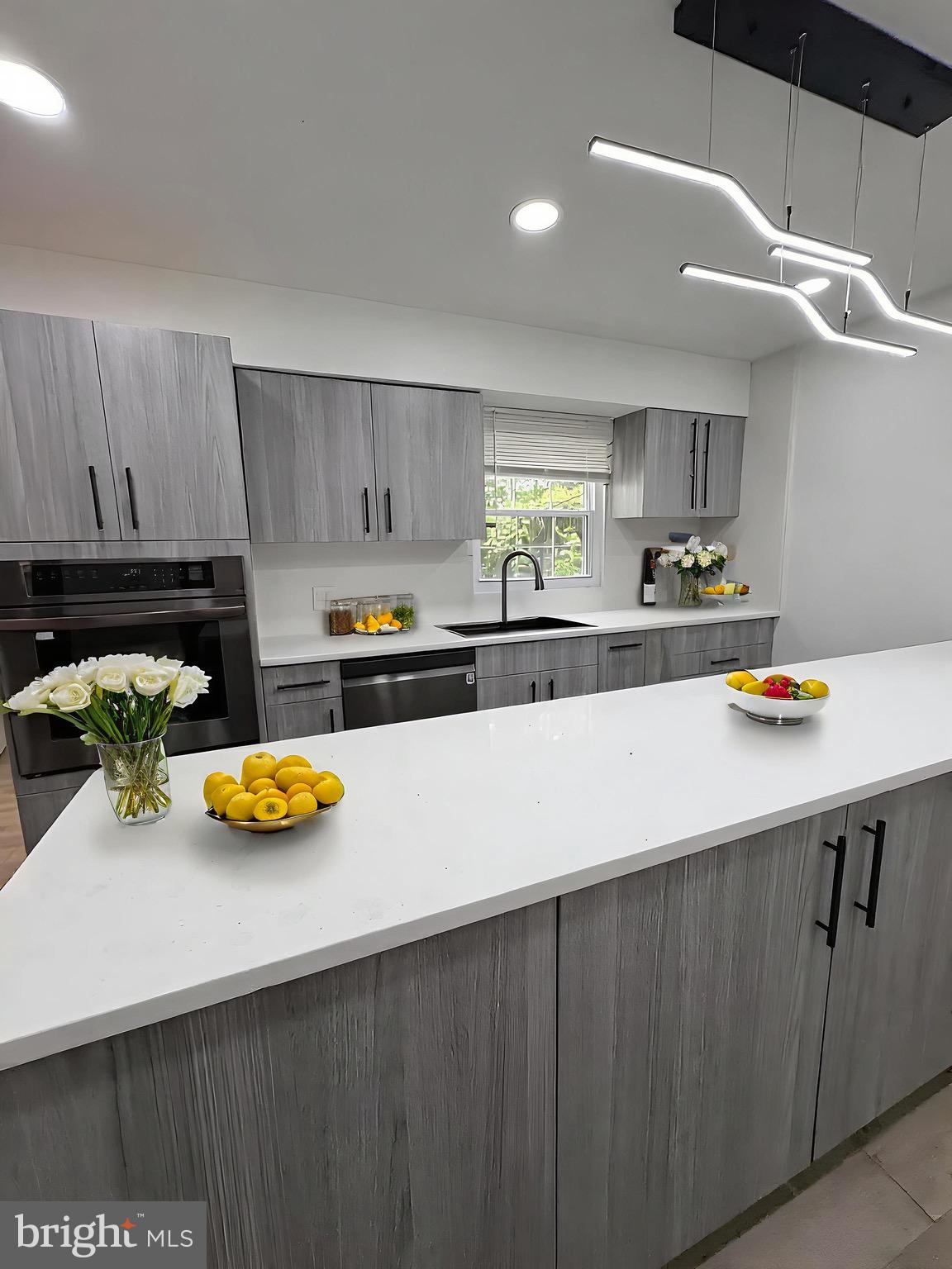 8908 Eastbourne Lane Laurel, MD 20708 - Photo 4 of 26 a kitchen with a sink a stove and chairs