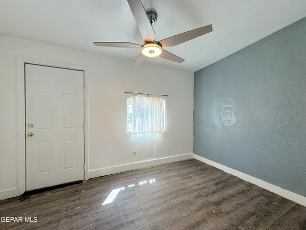 a view of an empty room with wooden floor