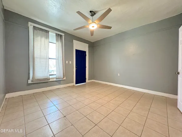 an empty room with fan and natural light