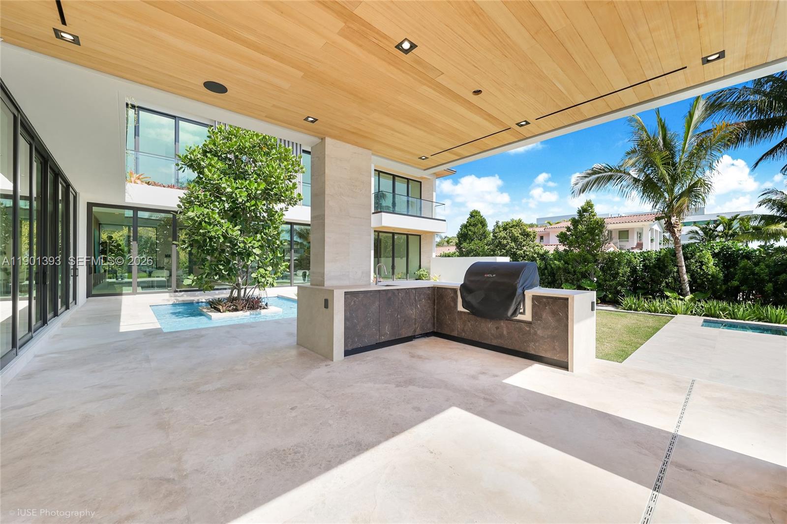 770 Lake Road Miami, FL 33137 - Photo 31 of 40 a view of a patio with couches and table and chairs under an umbrella