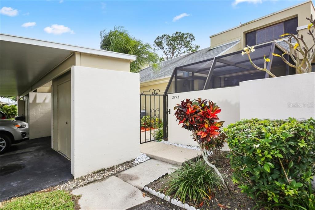 Gated entry to private courtyard, secure storage and covered carport on left.
