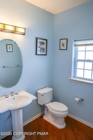 a bathroom with a toilet a sink and mirror