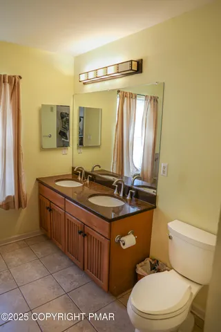a bathroom with a granite countertop toilet sink and mirror