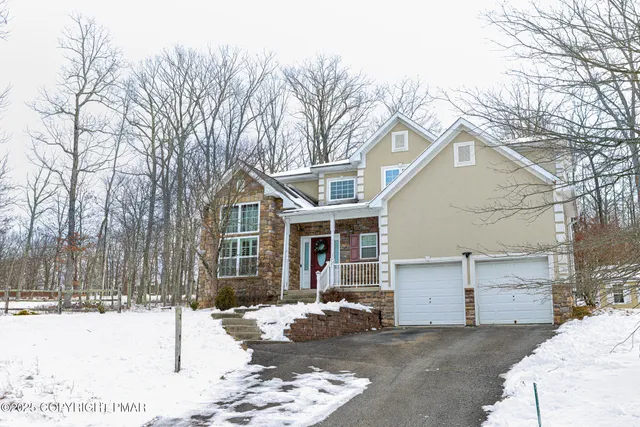 a front view of a house with a yard covered in snow