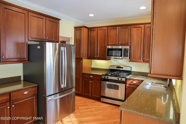 a kitchen with granite countertop a refrigerator stove and microwave