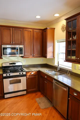 a kitchen with stainless steel appliances granite countertop a sink stove and microwave
