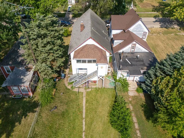 an aerial view of residential houses with outdoor space and trees