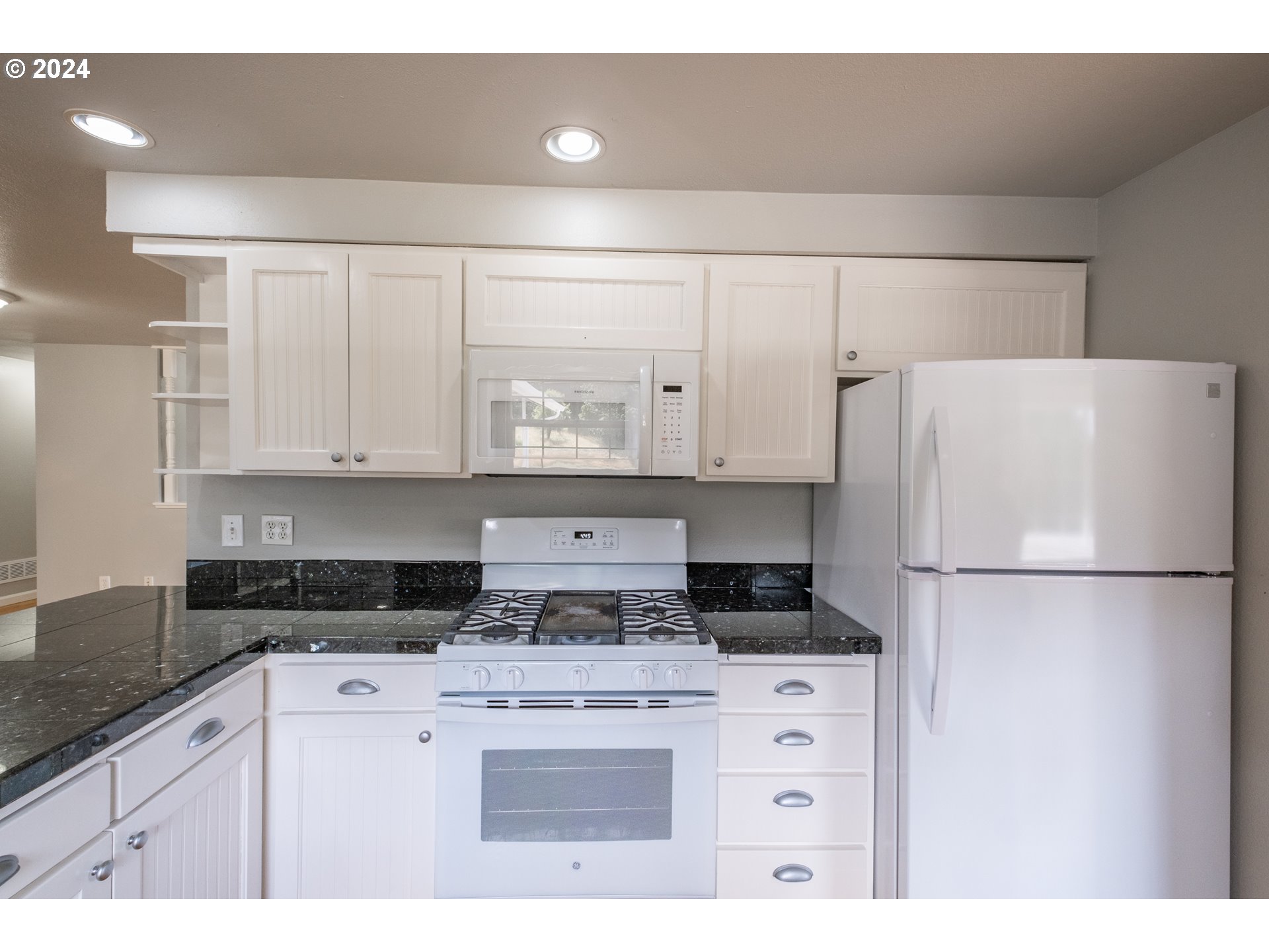 30521 Rancho Road Lebanon, OR 97355 - Photo 11 of 39 a kitchen with appliances a refrigerator and white cabinets