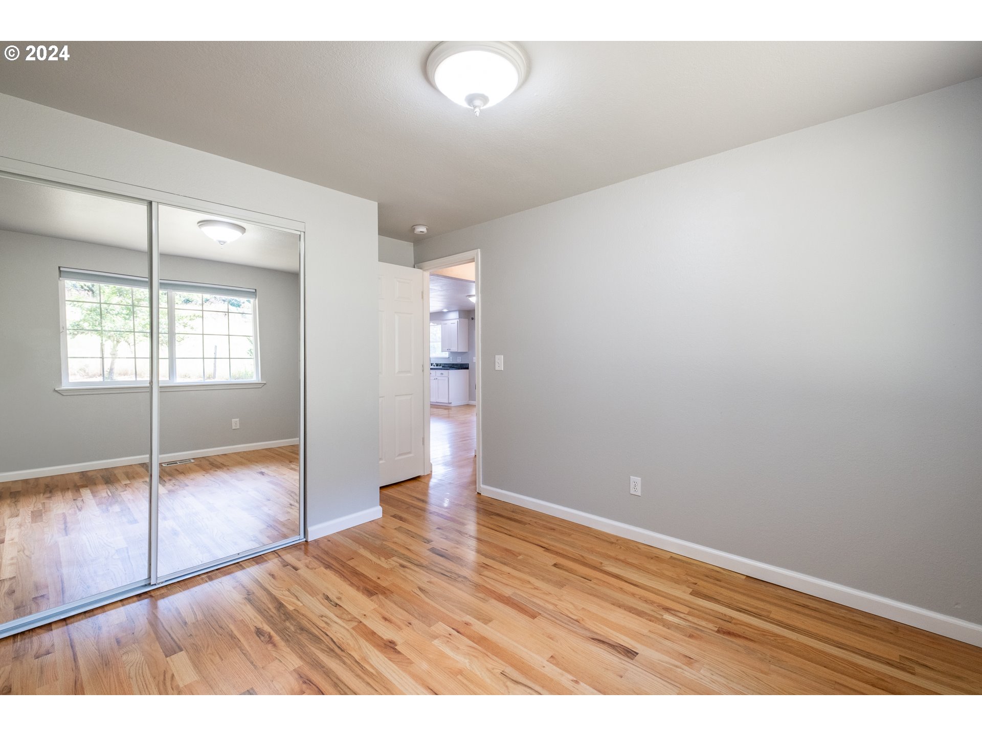 30521 Rancho Road Lebanon, OR 97355 - Photo 30 of 39 an empty room with wooden floor and windows