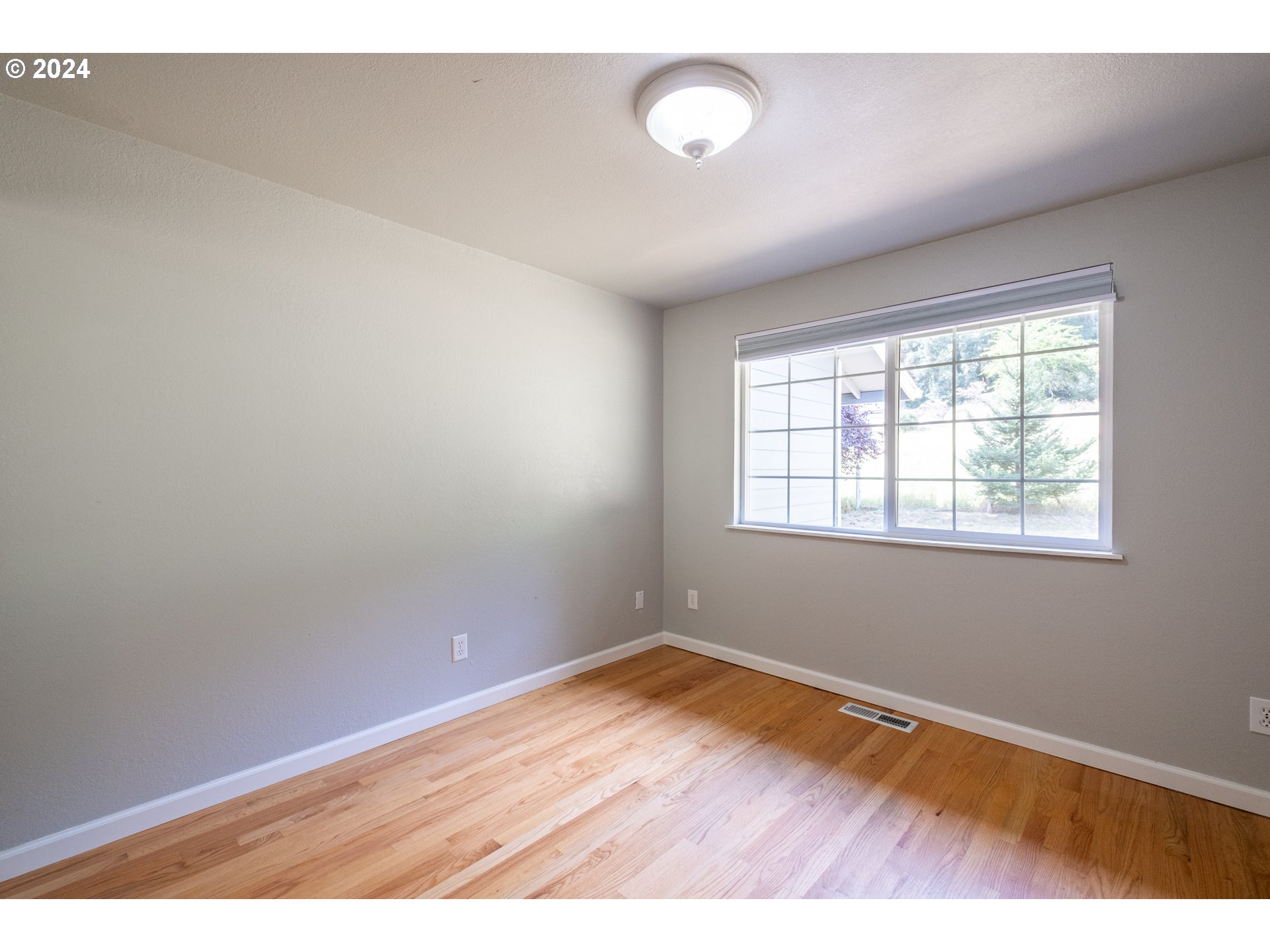 30521 Rancho Road Lebanon, OR 97355 - Photo 32 of 39 an empty room with wooden floor and windows