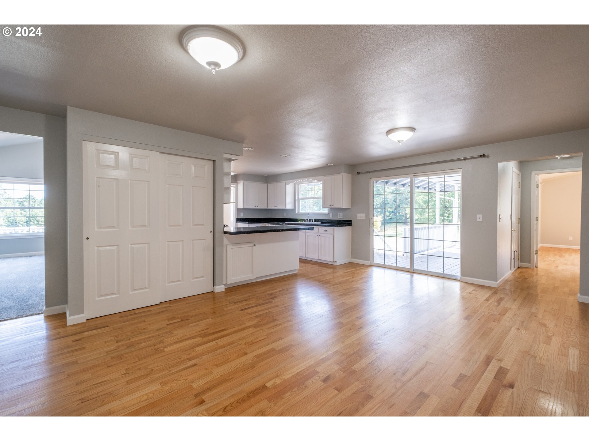 30521 Rancho Road Lebanon, OR 97355 - Photo 7 of 39 a view of empty room with wooden floor and kitchen