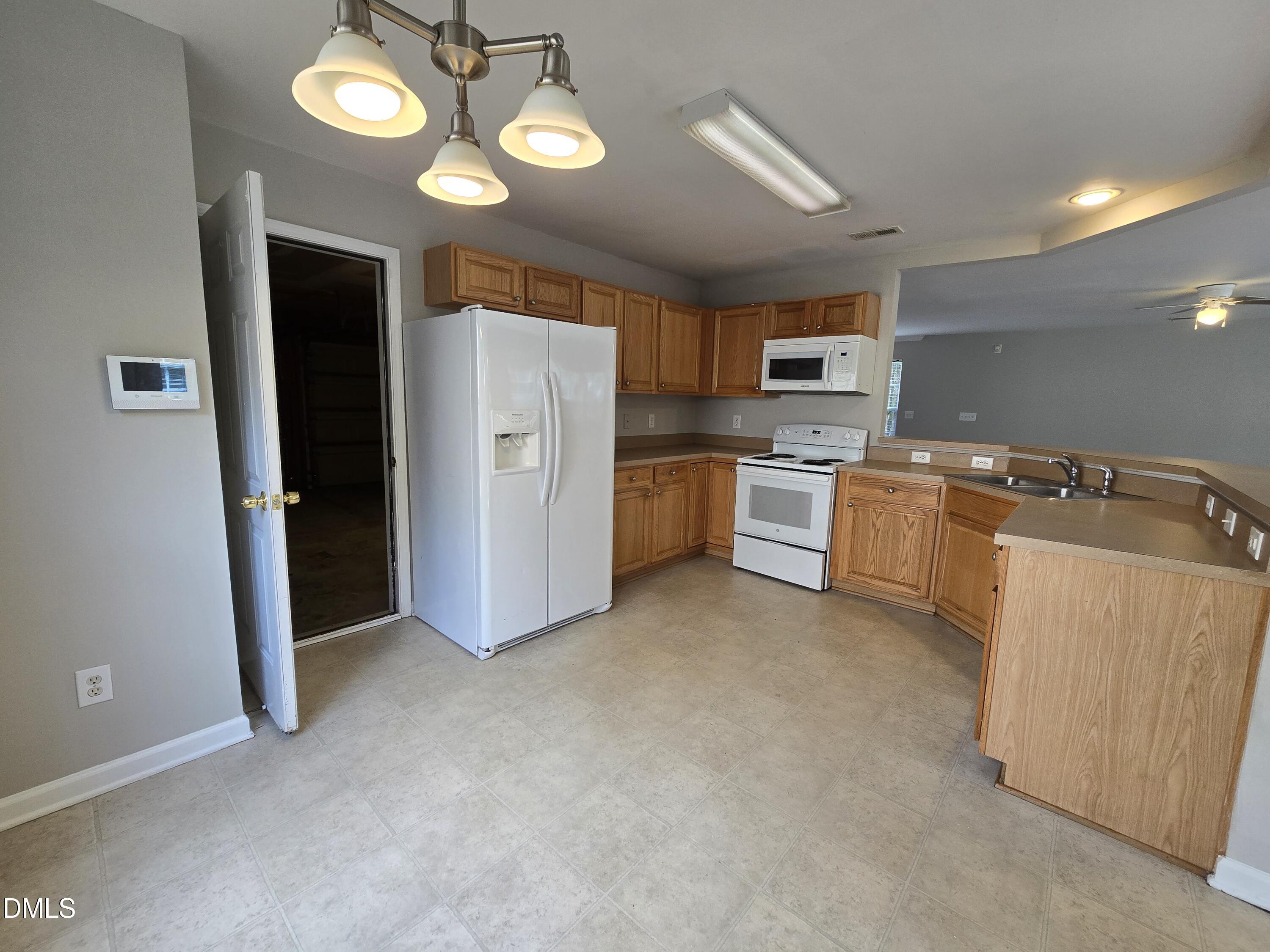 5030 Reservoir Road Raleigh, NC 27610 - Photo 13 of 31 a kitchen with stainless steel appliances granite countertop a refrigerator a stove top oven a sink and dishwasher