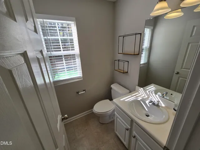 a bathroom with a sink a toilet and mirror