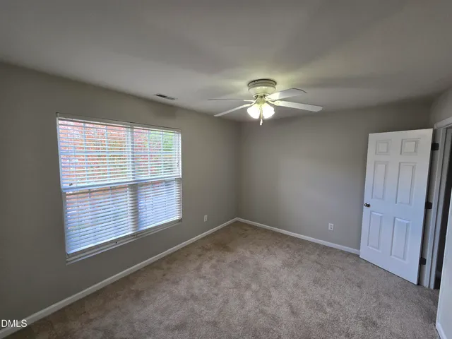 a view of a livingroom with a chandelier fan and a large window