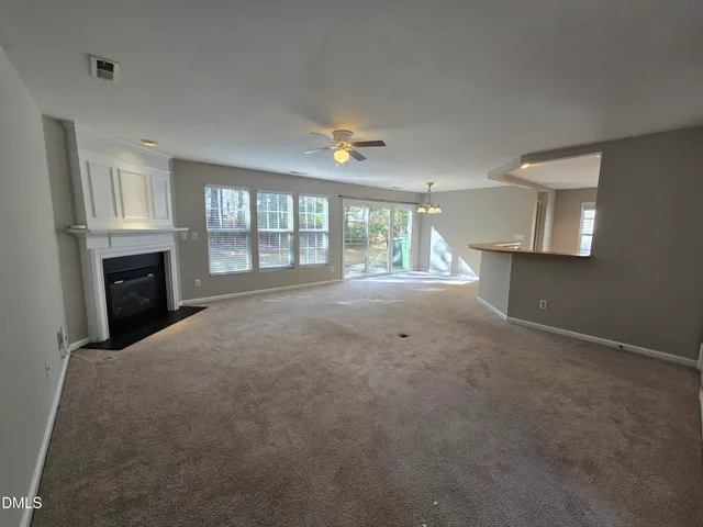 an empty room with windows and fireplace