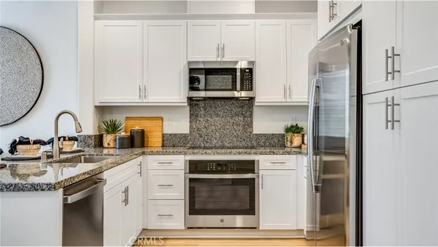 a kitchen with stainless steel appliances granite countertop a stove and a refrigerator