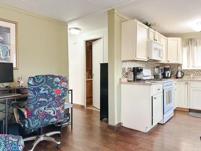 a kitchen with stainless steel appliances white cabinets and wooden floor