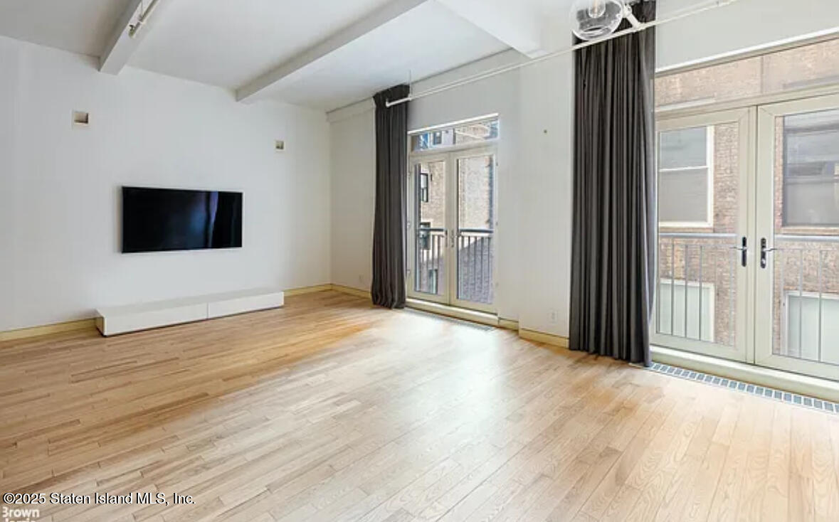 16 West 19th Street, Unit 9F Manhattan, NY 10011 - Photo 12 of 32 a view of a livingroom with wooden floor and a flat screen tv
