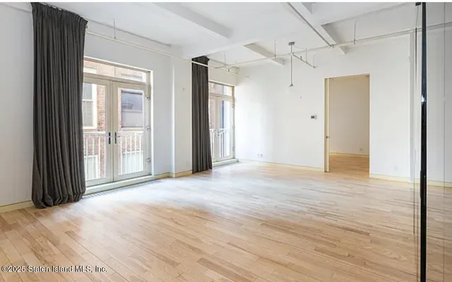 a view of a room with wooden floor and windows