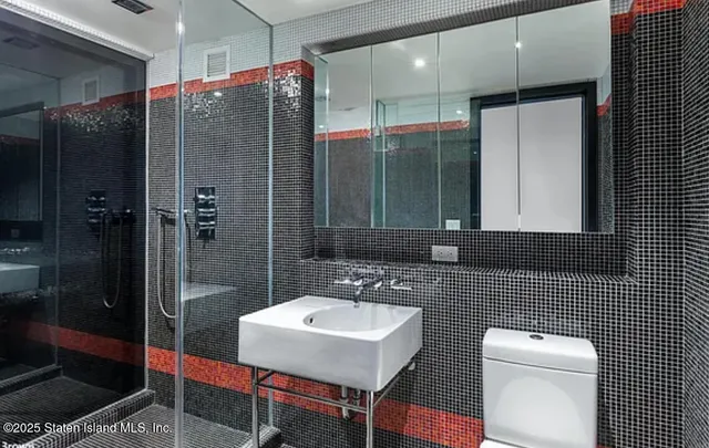 a bathroom with a sink a toilet and shower
