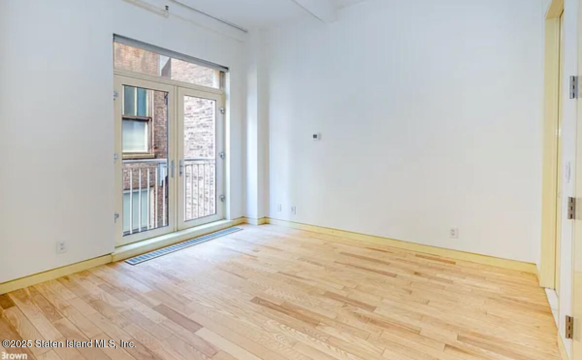16 West 19th Street, Unit 9F Manhattan, NY 10011 - Photo 17 of 32 a view of an empty room with wooden floor and a window
