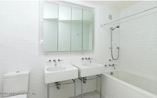 a bathroom with a bathtub shower sink vanity and toilet